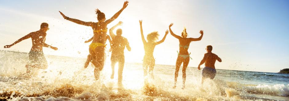 Teens running into the ocean