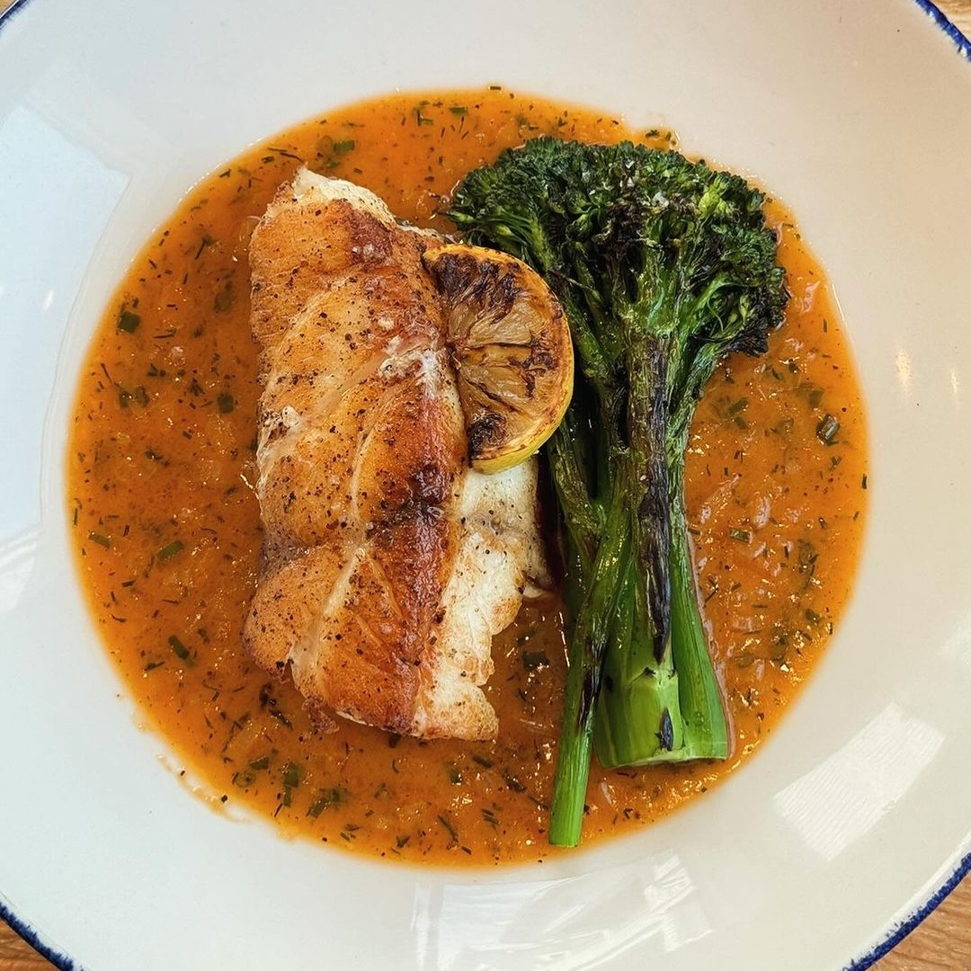 pan-seared market fish caught near wrightsville nc with orange tomato beurre blanc sauce, grilled broccolini and lemon