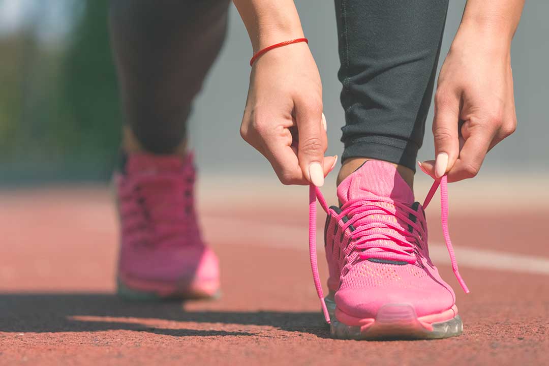 Girl tying her pink racing shoes